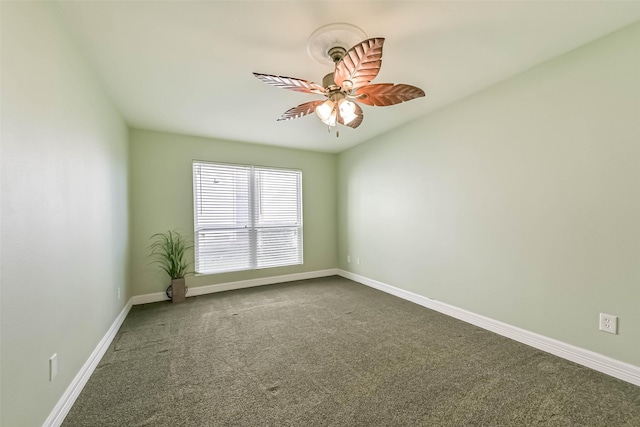 empty room featuring baseboards, dark carpet, and a ceiling fan