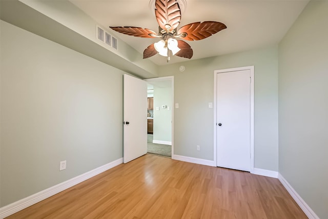 unfurnished bedroom featuring light wood-type flooring, a ceiling fan, baseboards, and visible vents