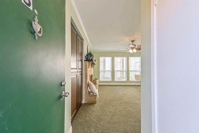 hallway featuring carpet flooring, ornamental molding, and baseboards