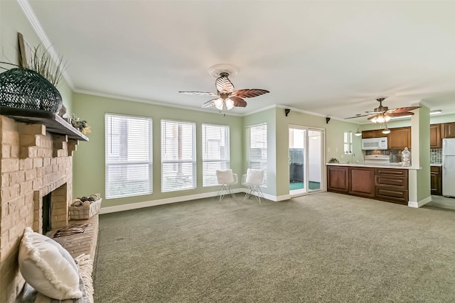 unfurnished living room with baseboards, ceiling fan, crown molding, and light carpet