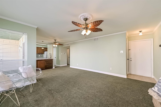 unfurnished living room featuring baseboards, ceiling fan, crown molding, and dark carpet