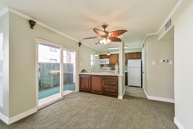 kitchen with light countertops, a sink, ornamental molding, and white appliances