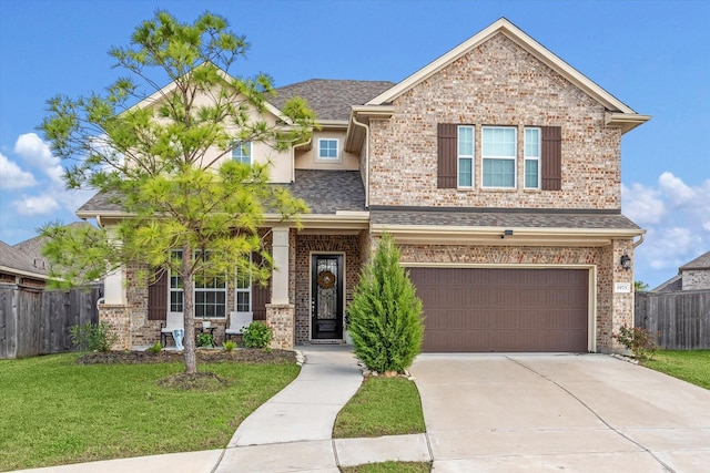 view of front facade featuring concrete driveway, an attached garage, fence, a front yard, and brick siding