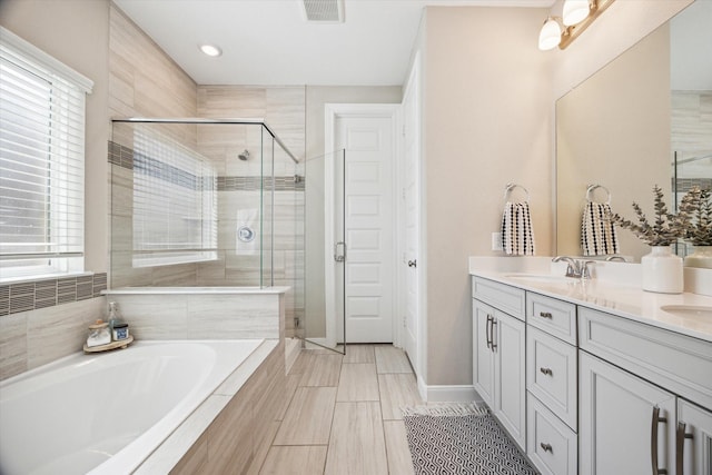 bathroom with vanity and independent shower and bath