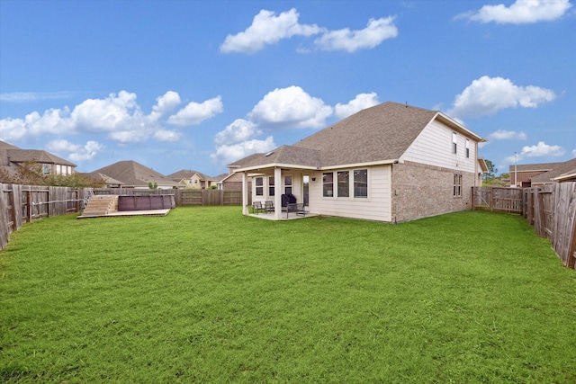 rear view of property with a pool, a patio area, and a lawn