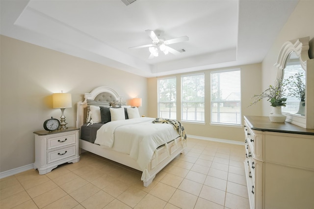 bedroom featuring a tray ceiling, ceiling fan, and light tile patterned floors