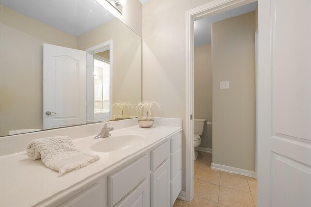 bathroom featuring tile patterned flooring, vanity, and toilet