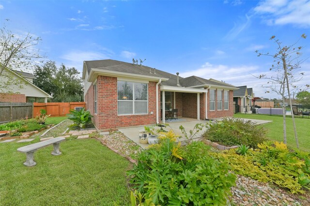 back of house featuring a yard and a patio area