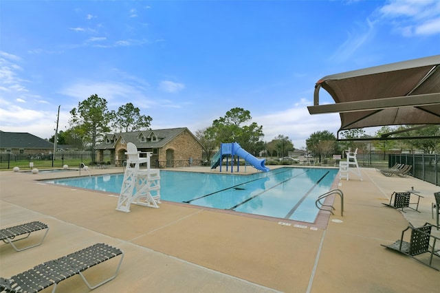 view of pool featuring a water slide and a patio