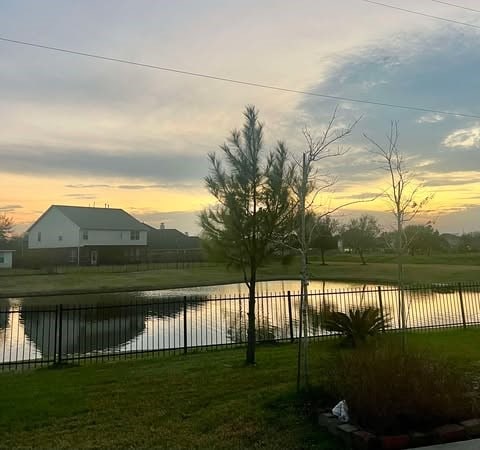 view of yard featuring a water view and fence