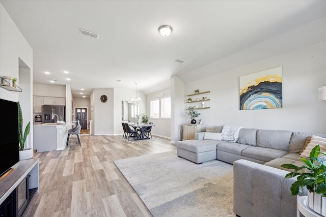 living room featuring light hardwood / wood-style floors and an inviting chandelier