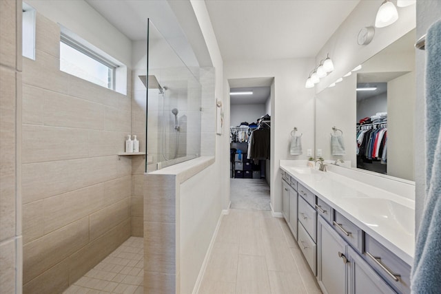 bathroom featuring a tile shower and vanity