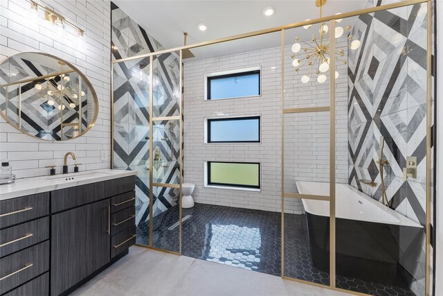 bathroom with an enclosed shower, vanity, tile walls, and tile patterned flooring