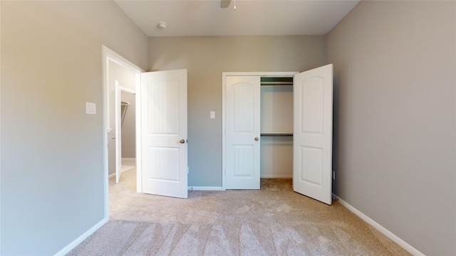 unfurnished bedroom featuring light colored carpet, a closet, and ceiling fan