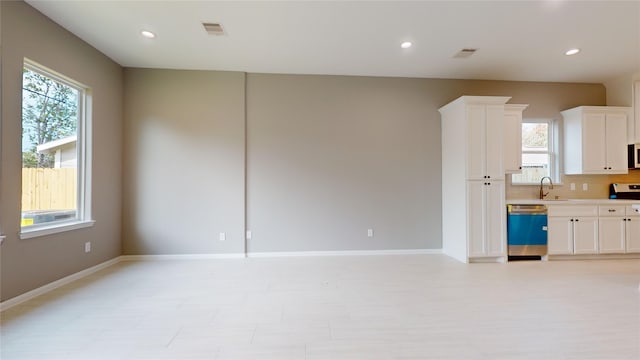 kitchen featuring a healthy amount of sunlight, sink, white cabinets, and stainless steel dishwasher