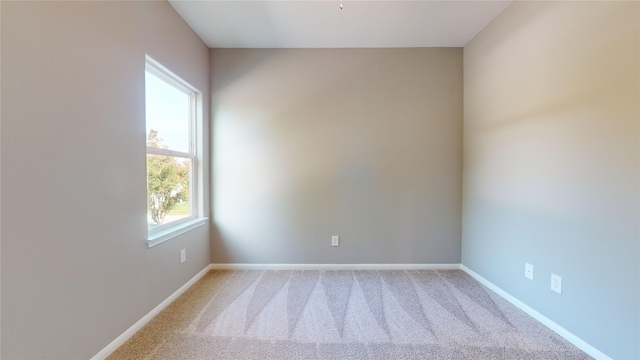 spare room featuring carpet floors and baseboards