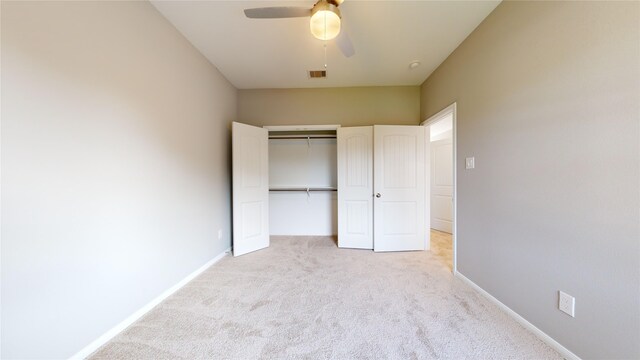 unfurnished bedroom with light carpet, a closet, and ceiling fan