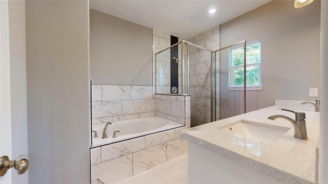 full bathroom with double vanity, a sink, a shower stall, and a bath