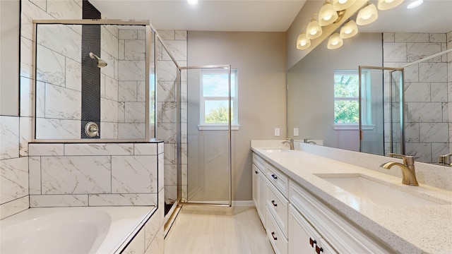 full bathroom with double vanity, a stall shower, and a sink