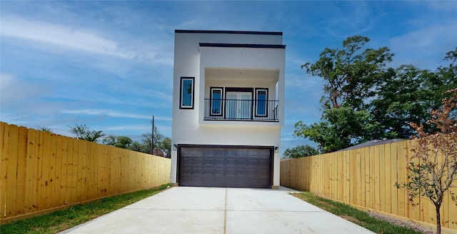 contemporary home featuring a garage, fence, concrete driveway, and stucco siding