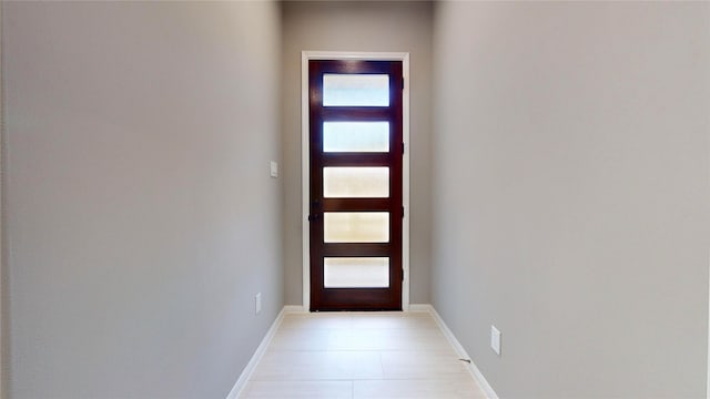 doorway to outside featuring light tile patterned floors and baseboards