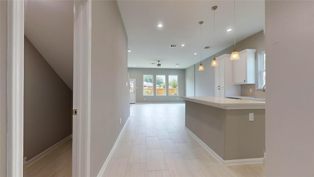 kitchen with white cabinets, sink, ceiling fan, and hanging light fixtures