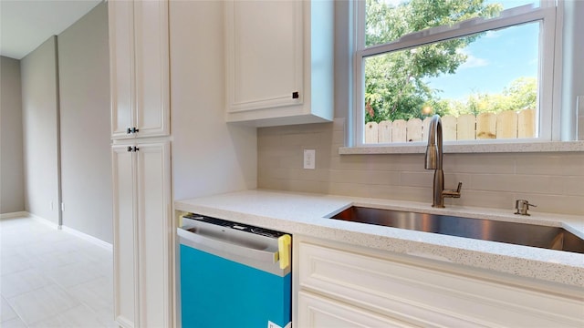 kitchen featuring backsplash, dishwasher, plenty of natural light, and sink