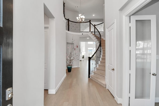 foyer with an inviting chandelier and light hardwood / wood-style flooring