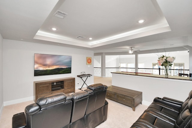 carpeted home theater featuring a tray ceiling and ceiling fan