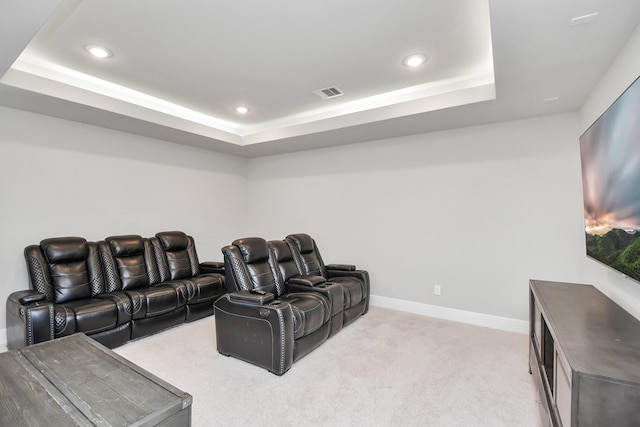 carpeted home theater with a raised ceiling