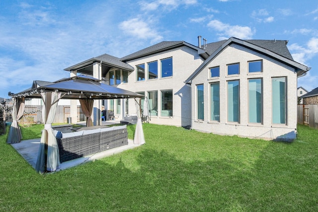 rear view of house featuring a gazebo, a patio area, outdoor lounge area, and a lawn