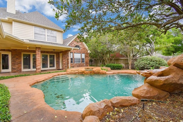 view of swimming pool with a patio area and a hot tub