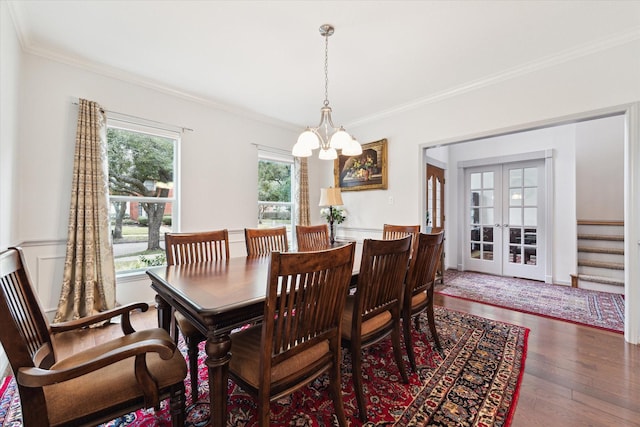 dining space featuring dark hardwood / wood-style floors, ornamental molding, french doors, and a notable chandelier