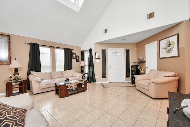 living room with light tile patterned floors, high vaulted ceiling, and a skylight