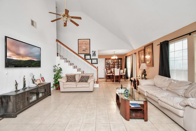 living room with light tile patterned floors, high vaulted ceiling, and ceiling fan with notable chandelier