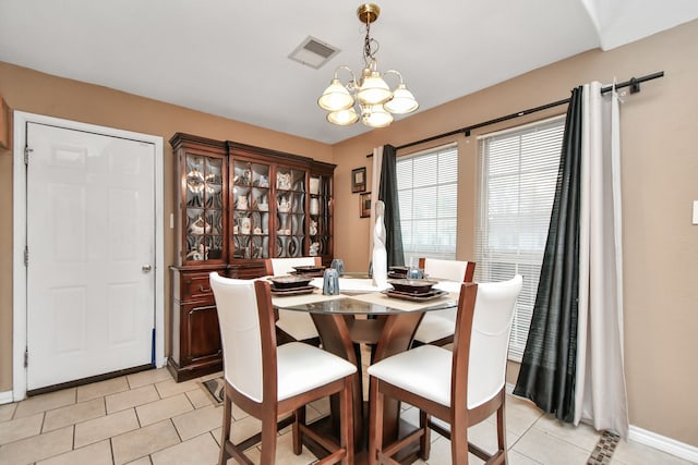 dining space featuring light tile patterned floors and a chandelier