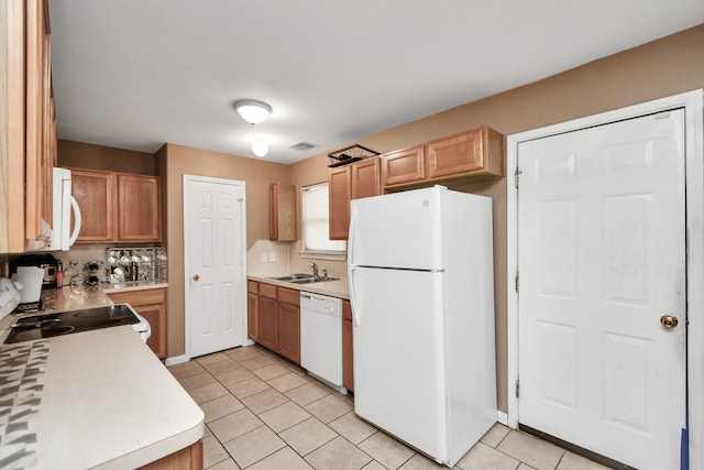 kitchen featuring tasteful backsplash, sink, light tile patterned floors, and white appliances