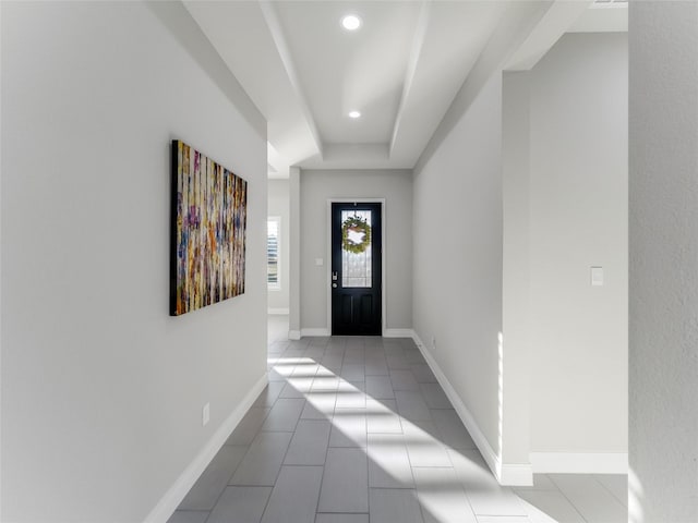 tiled entrance foyer with a tray ceiling