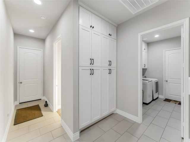 interior space featuring washing machine and dryer and light tile patterned floors