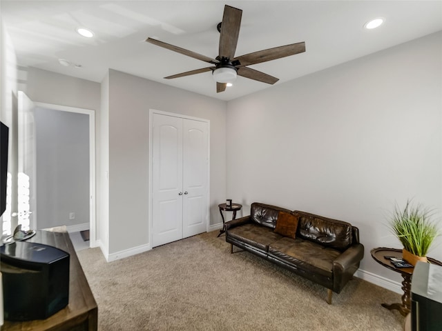 living area with light colored carpet and ceiling fan