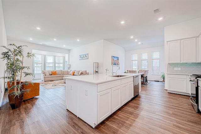 kitchen featuring appliances with stainless steel finishes, sink, a center island with sink, and white cabinets