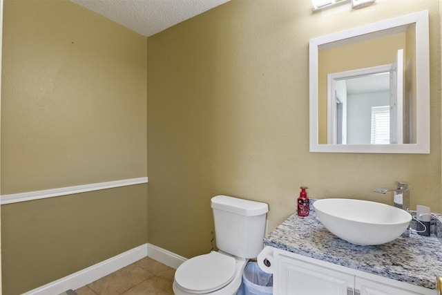 bathroom featuring tile patterned flooring, vanity, a textured ceiling, and toilet