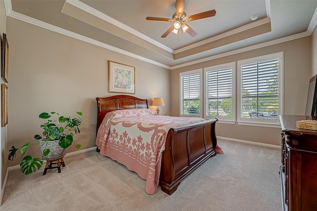 carpeted bedroom with ceiling fan, a raised ceiling, and ornamental molding