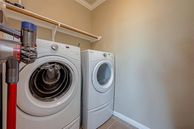 washroom with crown molding, light tile patterned flooring, and washer and dryer