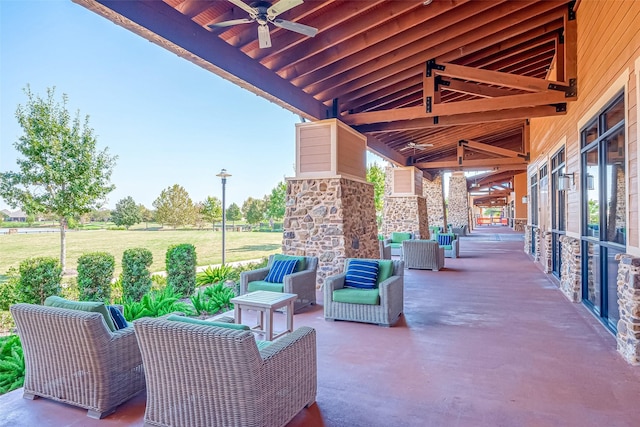 view of patio / terrace featuring ceiling fan and an outdoor stone fireplace