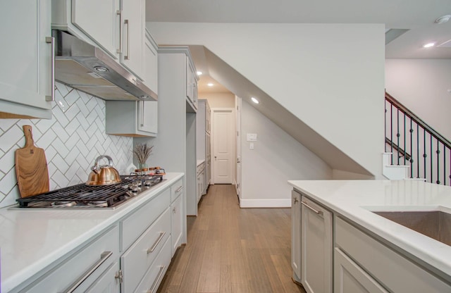 kitchen with tasteful backsplash, light wood-type flooring, and stainless steel gas stovetop