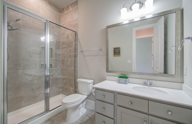 bathroom featuring vanity, toilet, and a shower with shower door