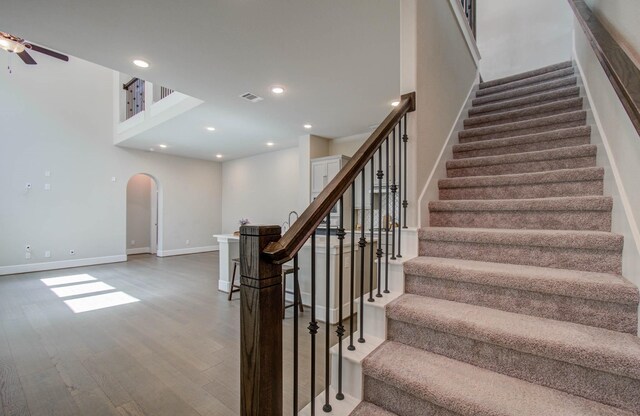 stairs with ceiling fan and wood-type flooring