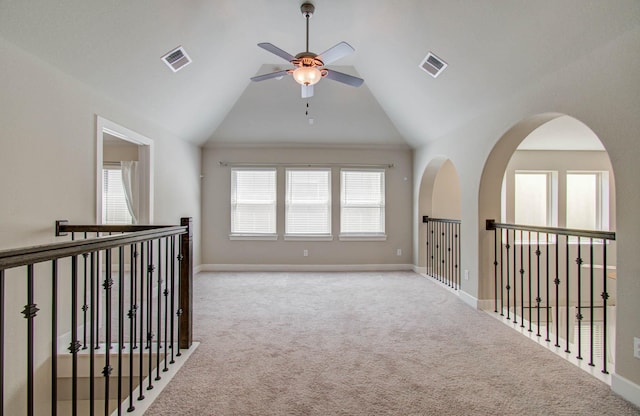 carpeted empty room with high vaulted ceiling, ceiling fan, and a wealth of natural light