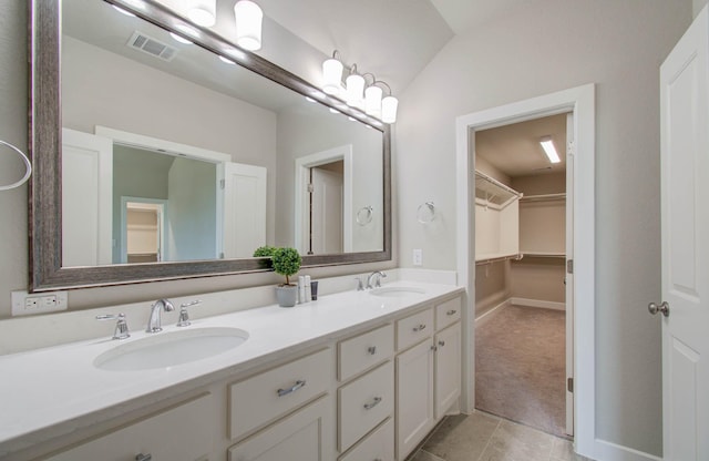 bathroom featuring tile patterned floors, vanity, and lofted ceiling